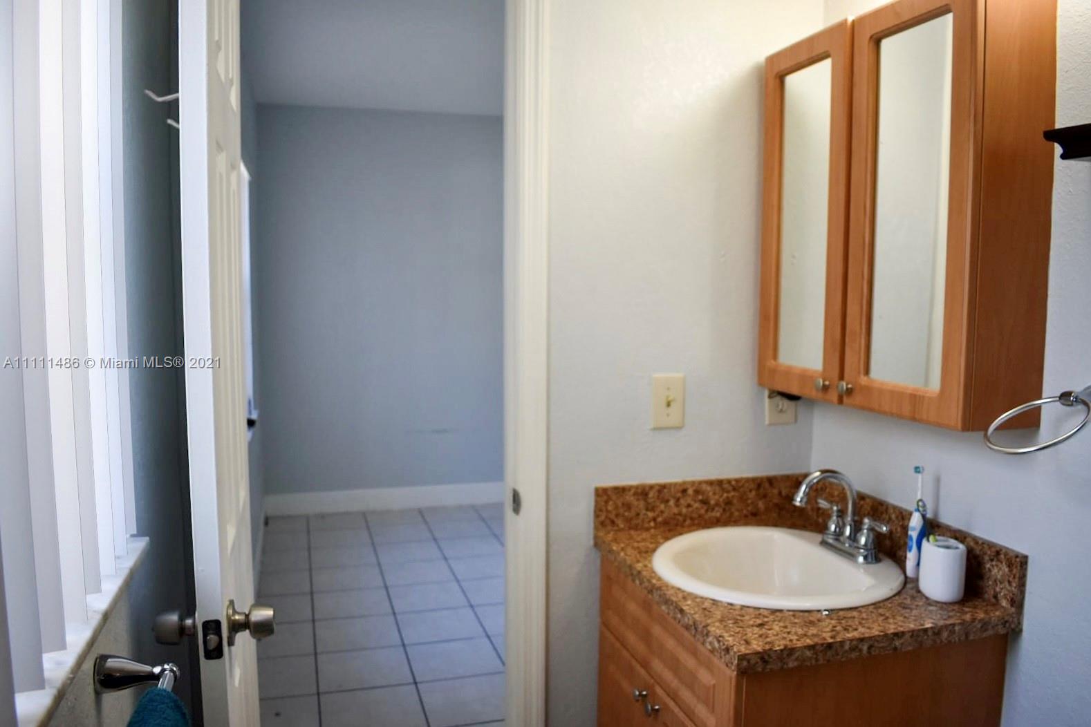 18280 Mediterranean Boulevard, Unit 43 Hialeah, FL 33015 - Photo 20 of 28 a bathroom with a granite countertop sink and a mirror