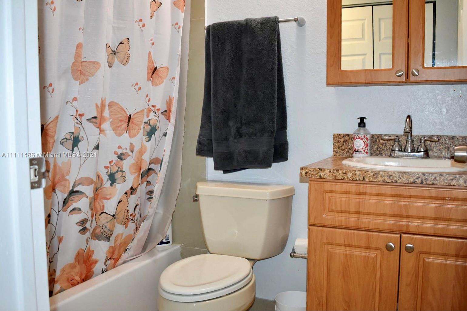 18280 Mediterranean Boulevard, Unit 43 Hialeah, FL 33015 - Photo 24 of 28 a bathroom with a granite countertop toilet sink and mirror
