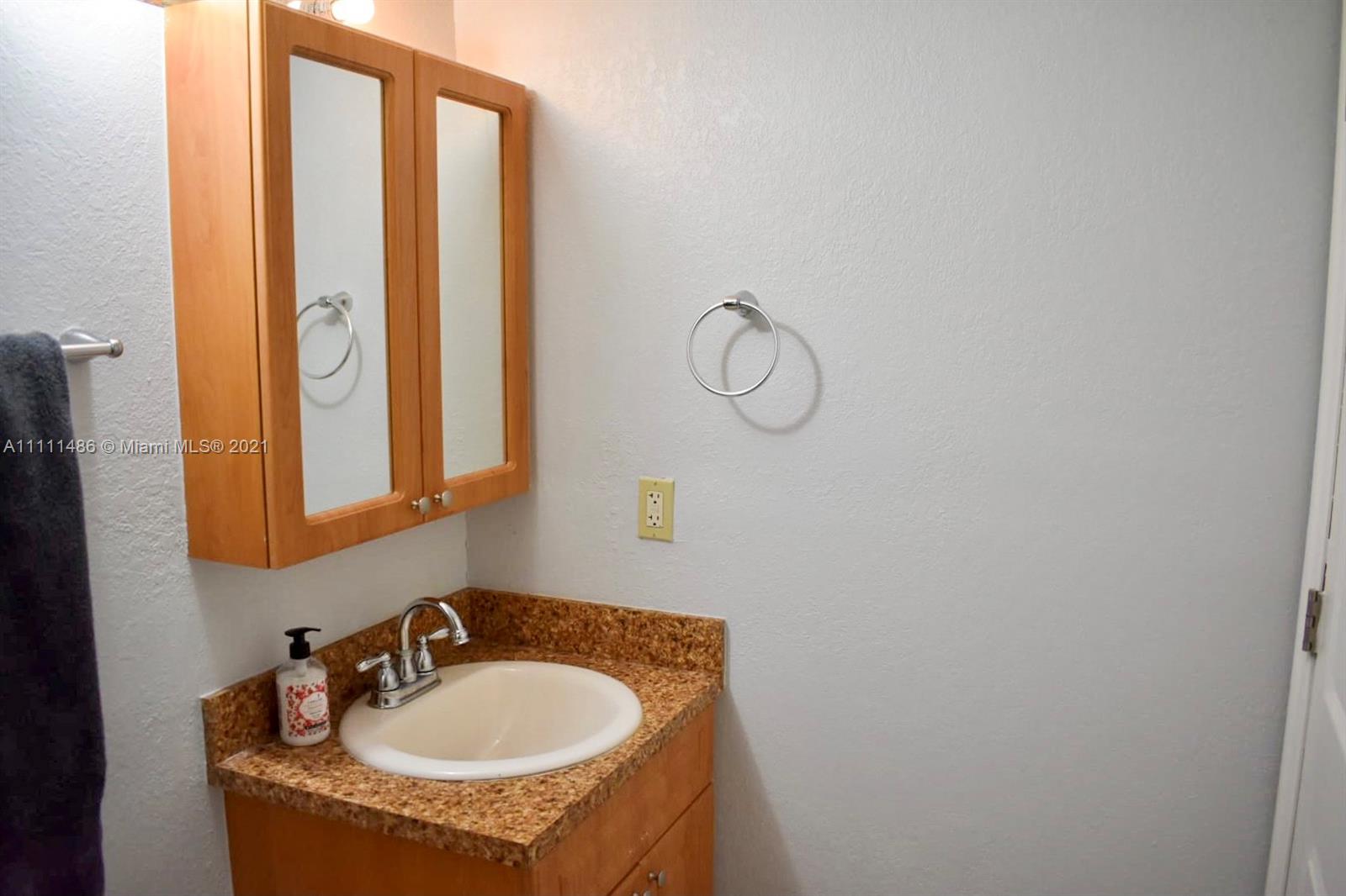 18280 Mediterranean Boulevard, Unit 43 Hialeah, FL 33015 - Photo 26 of 28 a bathroom with a sink and a mirror