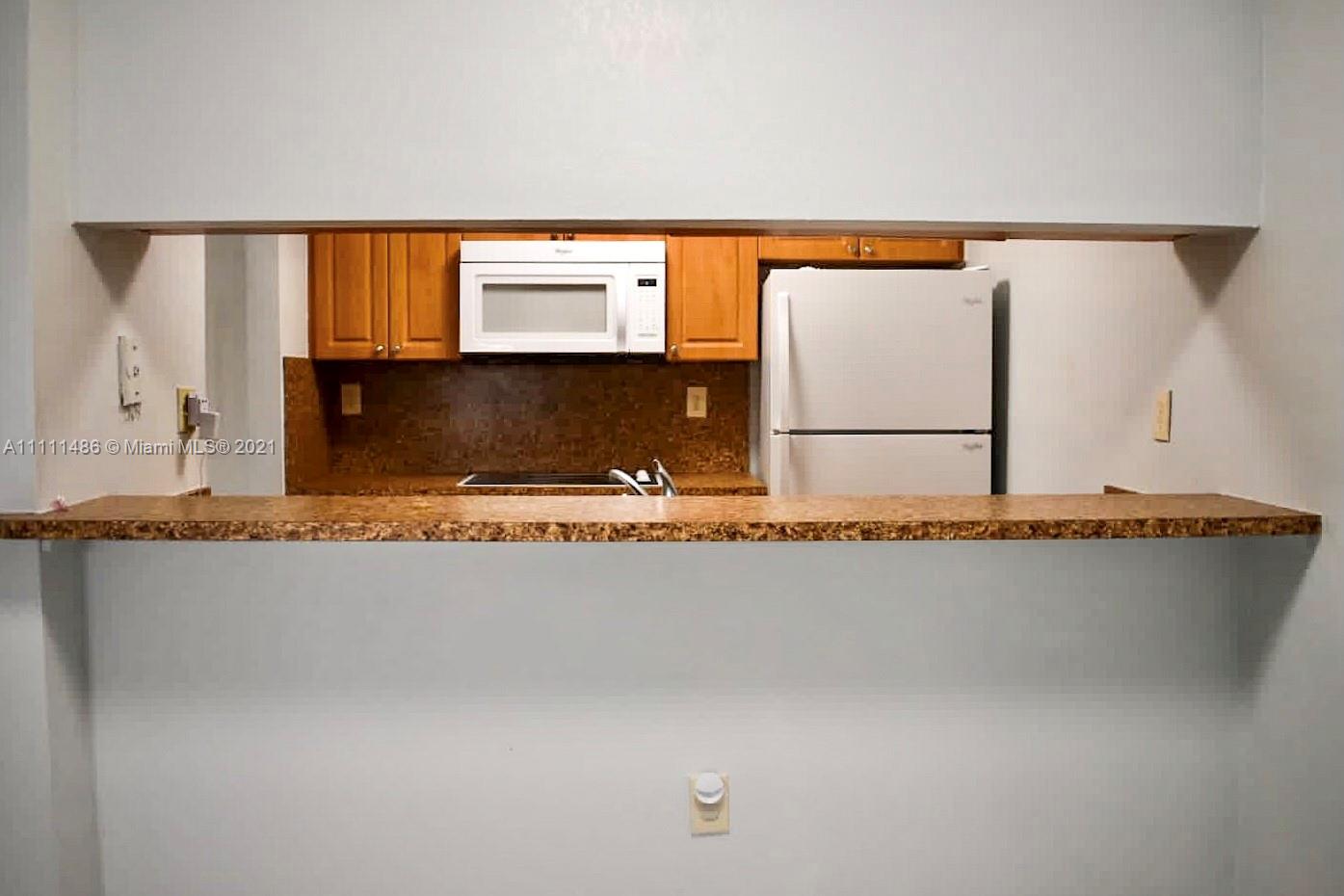 18280 Mediterranean Boulevard, Unit 43 Hialeah, FL 33015 - Photo 7 of 28 a view of a kitchen with a sink and cabinets