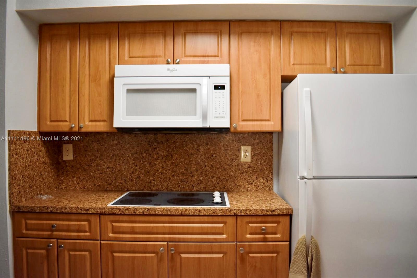 18280 Mediterranean Boulevard, Unit 43 Hialeah, FL 33015 - Photo 8 of 28 a kitchen with granite countertop cabinets and refrigerator