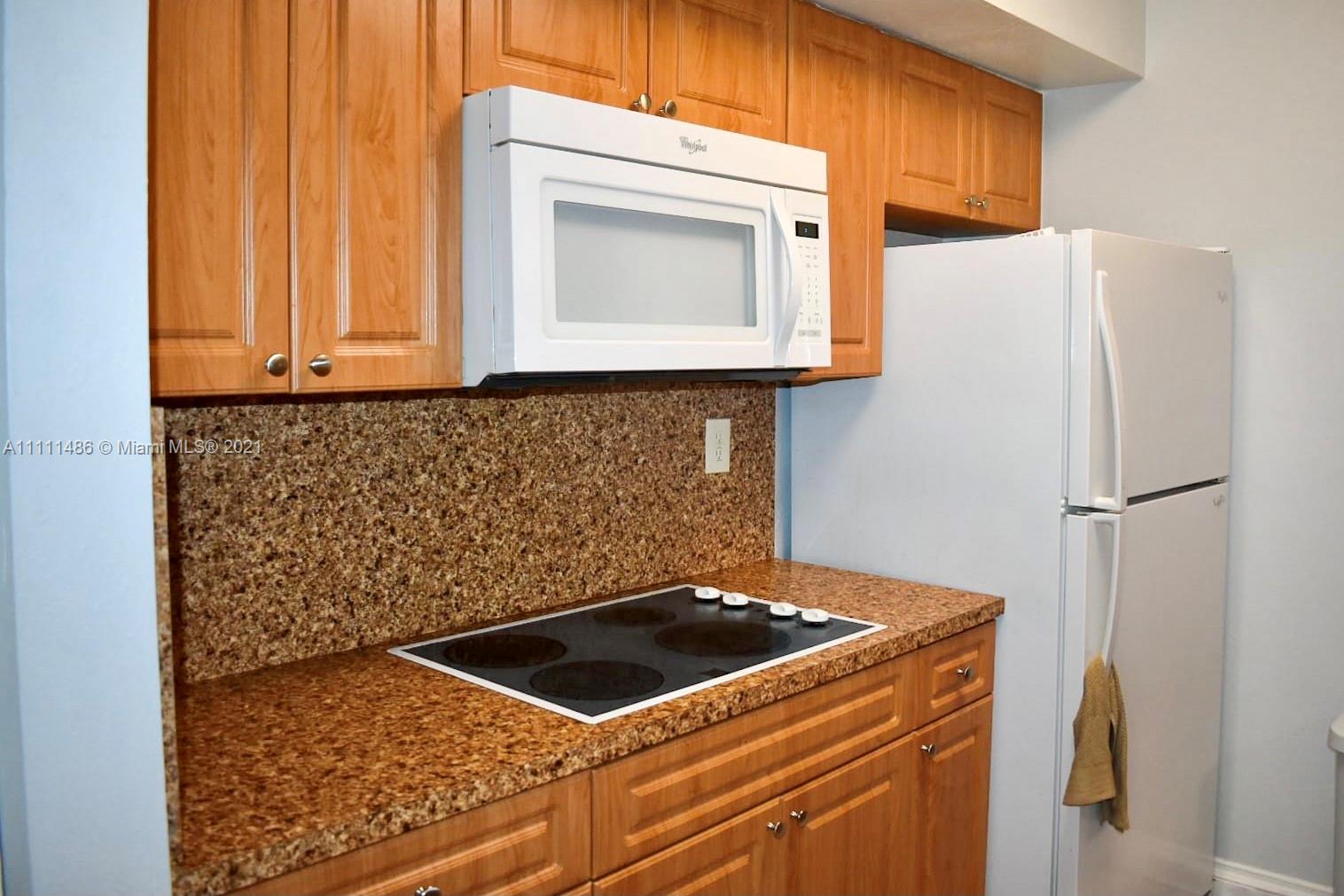 18280 Mediterranean Boulevard, Unit 43 Hialeah, FL 33015 - Photo 9 of 28 a kitchen with a refrigerator and a stove