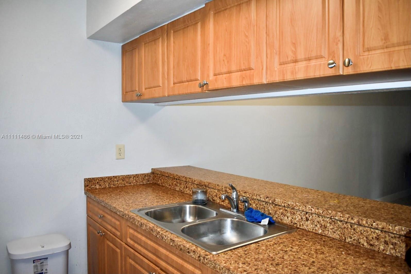 18280 Mediterranean Boulevard, Unit 43 Hialeah, FL 33015 - Photo 10 of 28 a kitchen with a sink and cabinets
