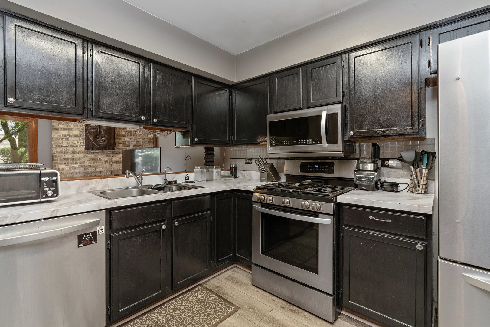709 Meadows Boulevard Addison, IL 60101 - Photo 6 of 22 a kitchen with stainless steel appliances wooden cabinets and a stove top oven