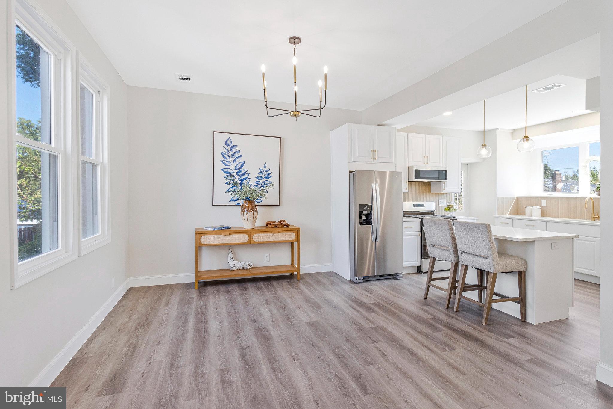 2140 32nd Street Southeast Washington, DC 20020 - Photo 14 of 50 a dining room with wooden floor a chandelier a wooden table and chairs