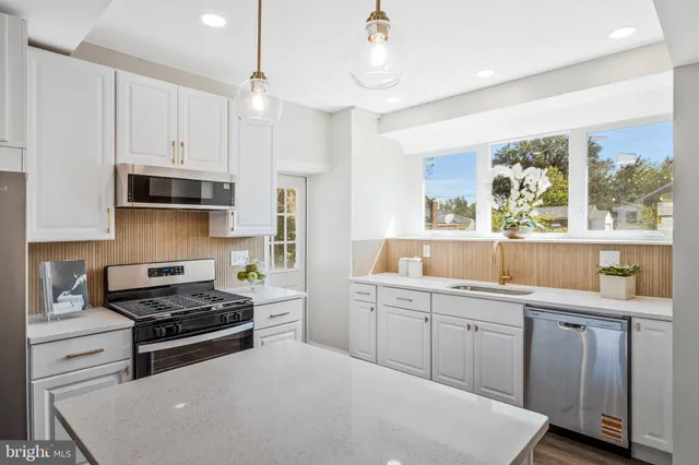 a kitchen with a sink a stove and cabinets