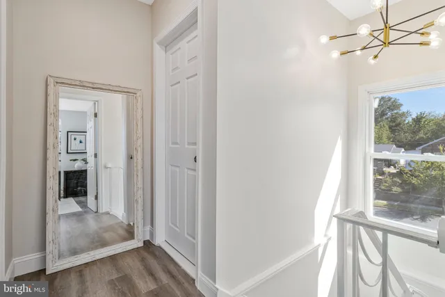 a view of a hallway with wooden floor and a livingroom