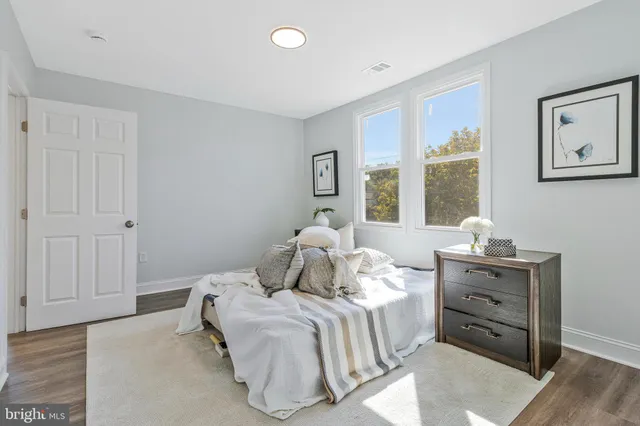 a bedroom with a bed and wooden floor