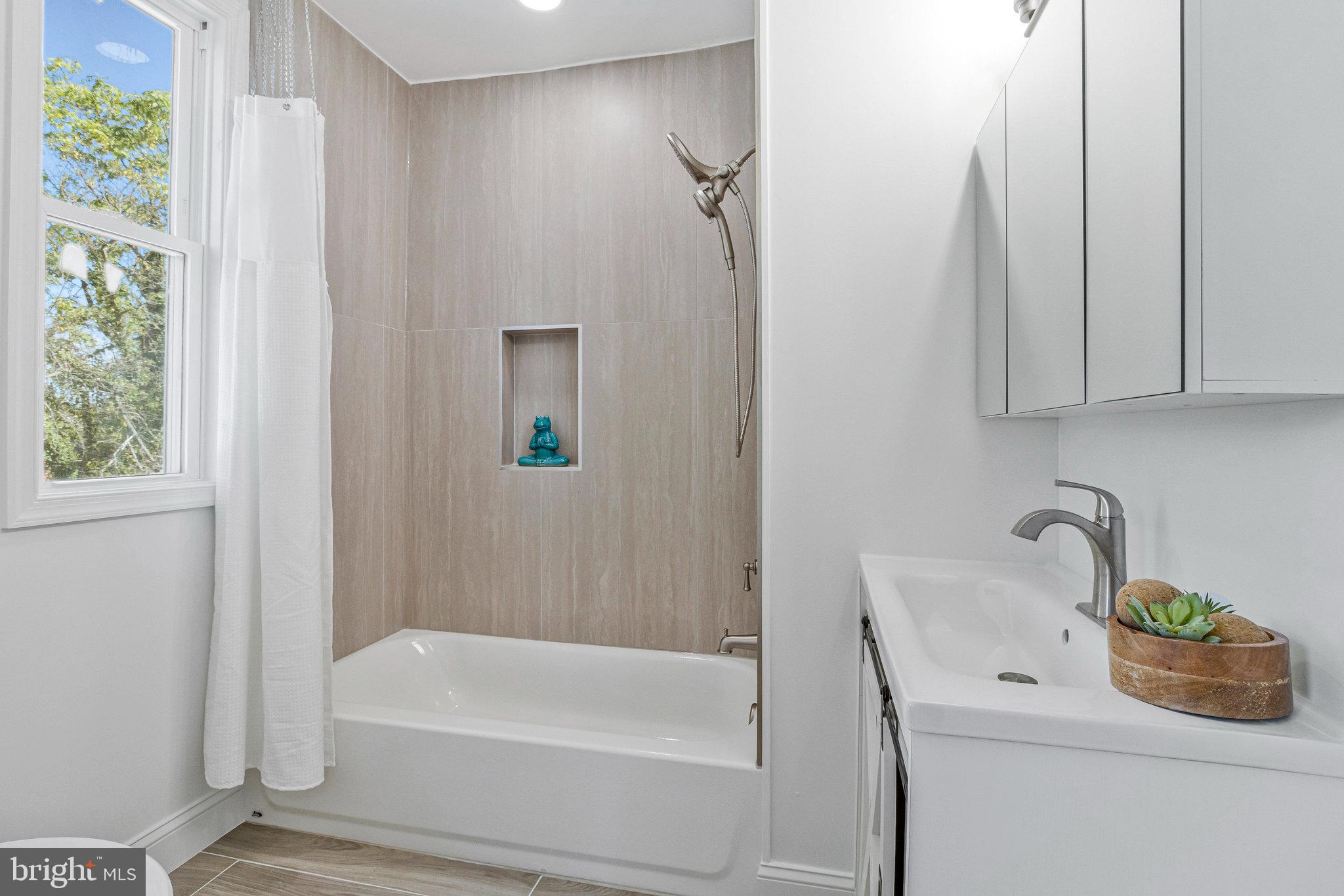 2140 32nd Street Southeast Washington, DC 20020 - Photo 29 of 50 a bathroom with a sink a bathtub and a window