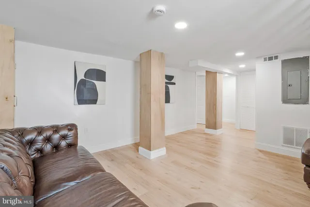 a living room with furniture and a wooden floor