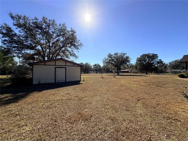 an empty room with windows and chandelier fan