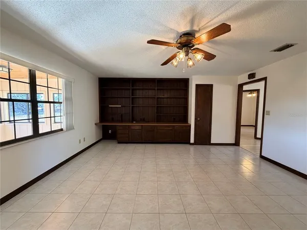 a view of a livingroom with wooden floor and a ceiling fan