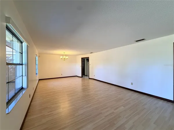an empty room with wooden floor and ceiling fan