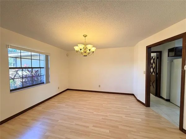 an empty room with wooden floor and ceiling fan
