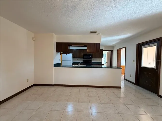 an aerial view of a house with a yard and a large tree