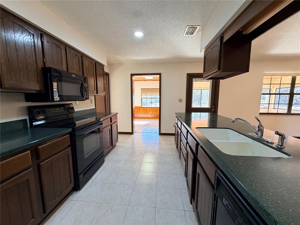 35324 Blanton Road Dade City, FL 33523 - Photo 29 of 49 a kitchen with stainless steel appliances granite countertop a sink and stove top oven