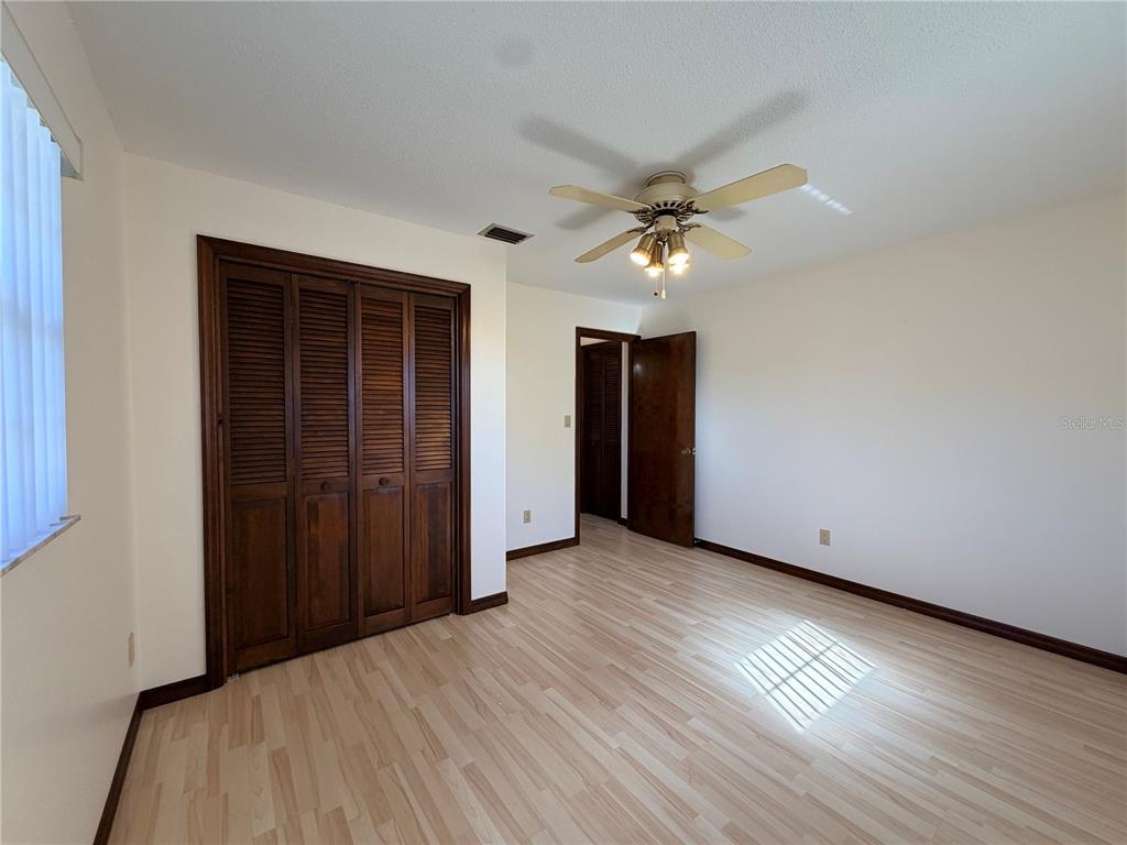 35324 Blanton Road Dade City, FL 33523 - Photo 38 of 49 an empty room with wooden floor and ceiling fan