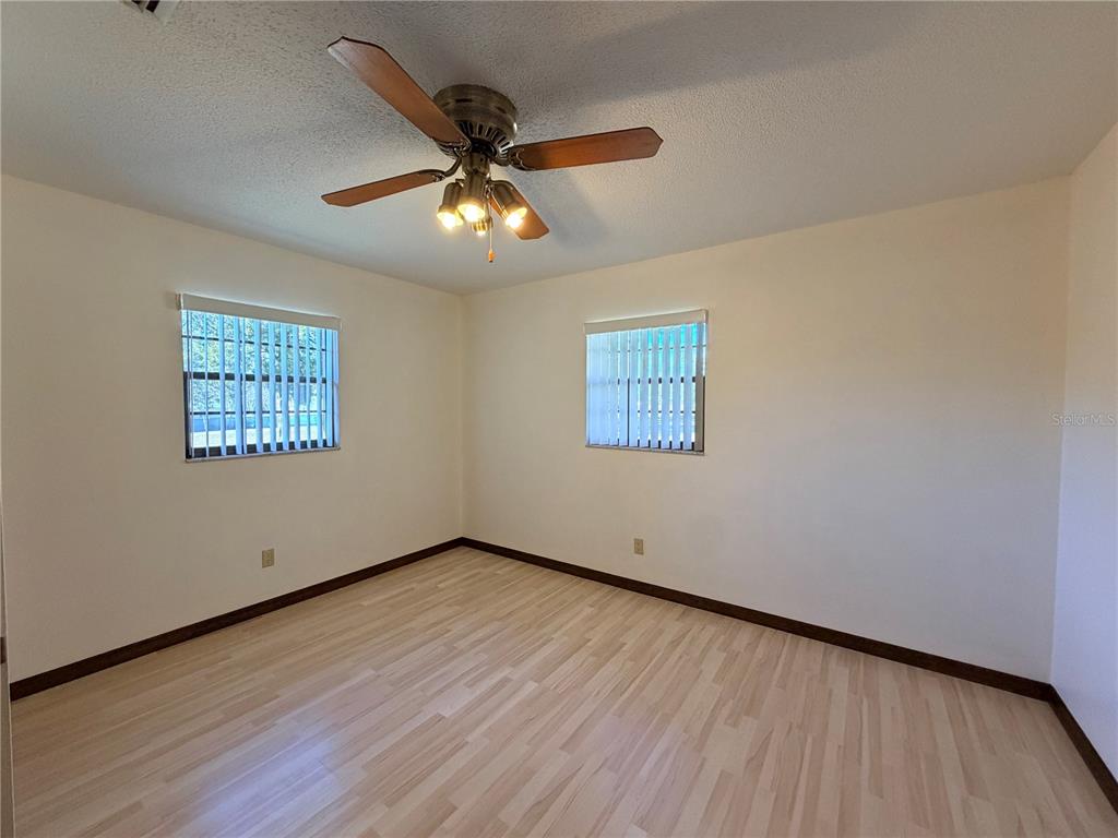 35324 Blanton Road Dade City, FL 33523 - Photo 43 of 49 a view of an empty room with wooden floor and a ceiling fan