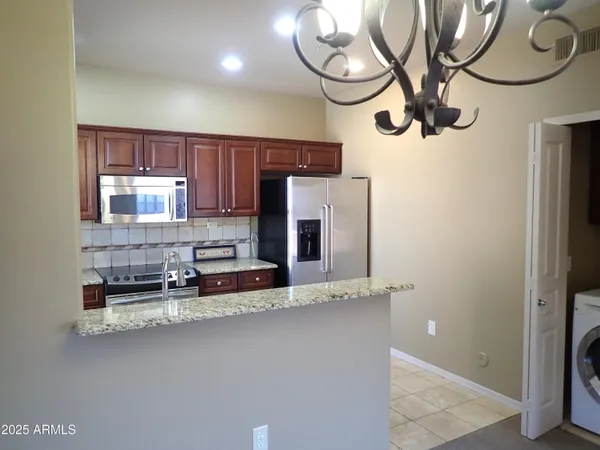 a kitchen with stainless steel appliances granite countertop wooden cabinets and a sink