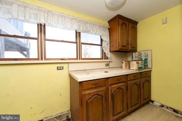a kitchen with a sink a window and cabinets