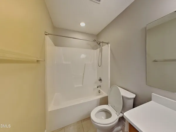 a white toilet sitting next to a bath tub and a shower