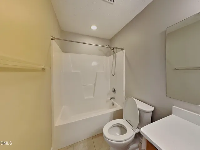 a white toilet sitting next to a bath tub and a shower