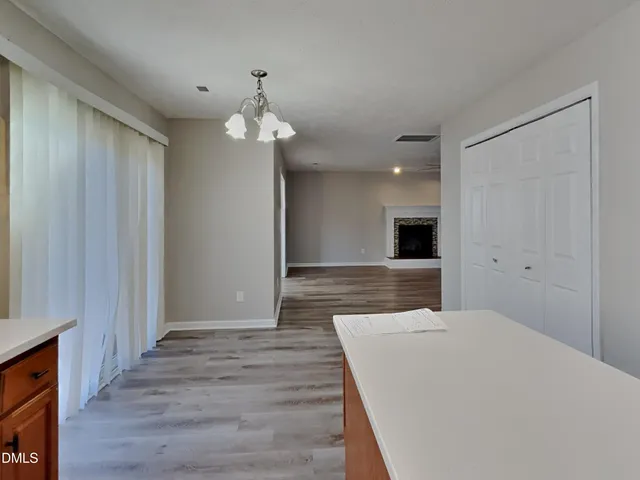 a large bedroom with chandelier and wooden floor