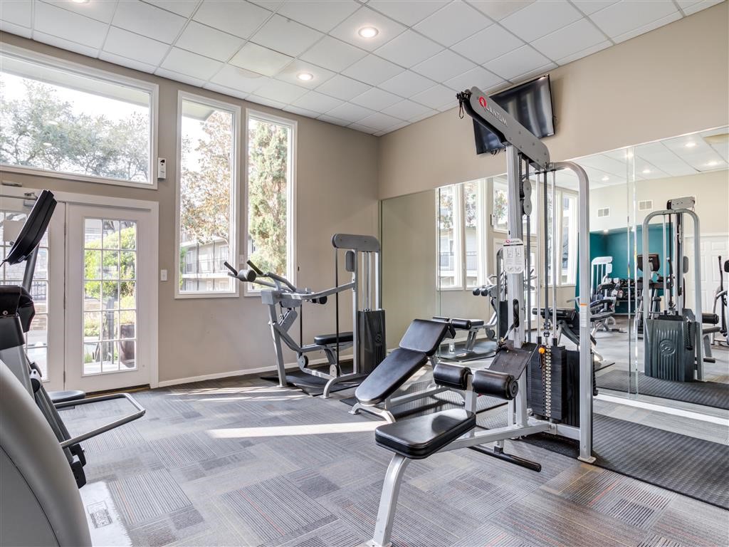 7315 Brompton Street, Unit 247A Houston, TX 77025 - Photo 12 of 13 a room with gym equipment and floor to ceiling windows