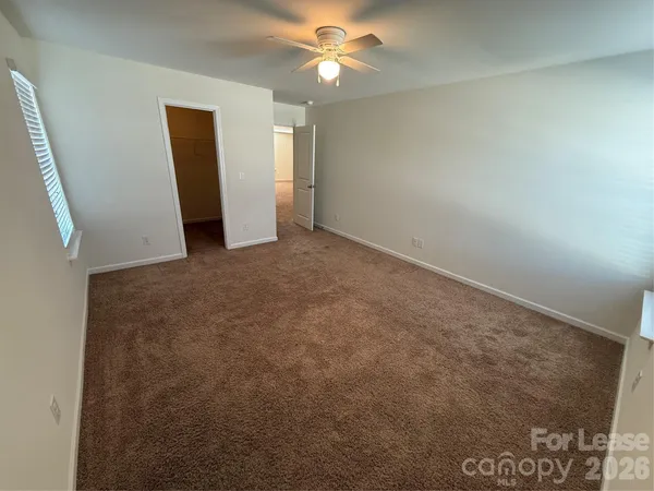 an empty room with closet and a chandelier fan