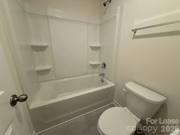 a white toilet and tub sitting next to a bathroom sink
