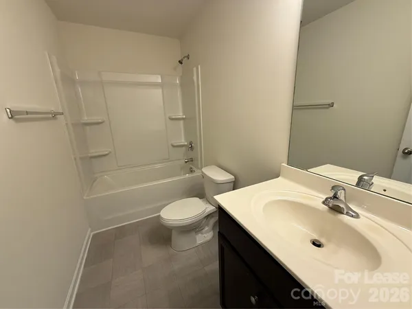 a bathroom with a sink toilet vanity and shower