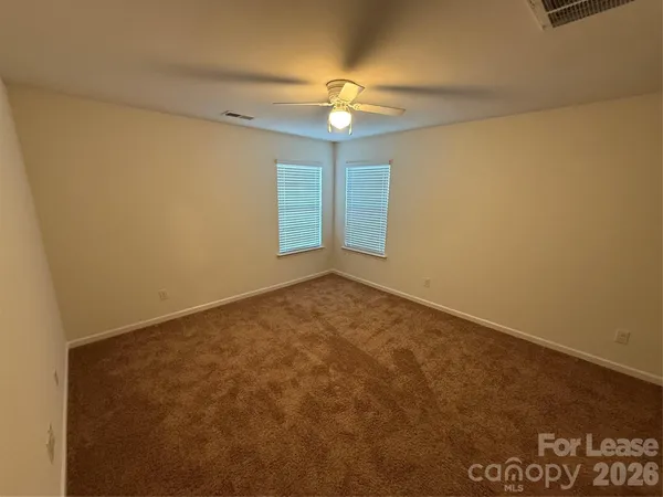 an empty room with a ceiling fan and a window