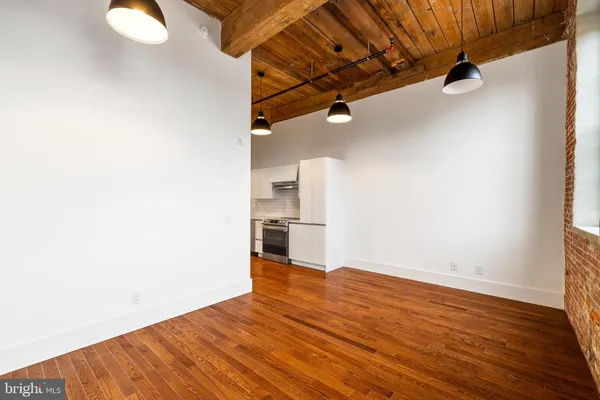a view of a room with wooden floor and white walls