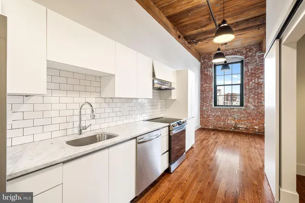 a kitchen with a sink stove and cabinets
