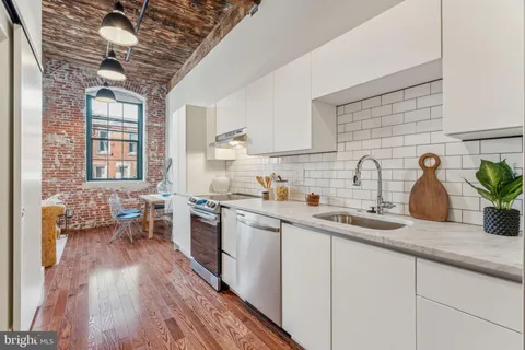 a kitchen with sink a stove and cabinets