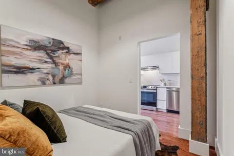 a bedroom with a bed and a painting on the wall