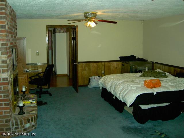 1201 Hibiscus Street St. Augustine, FL 32084 - Photo 13 of 16 a bedroom with a bed and a chandelier