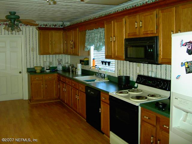 1201 Hibiscus Street St. Augustine, FL 32084 - Photo 6 of 16 a kitchen with stainless steel appliances granite countertop a sink stove and cabinets