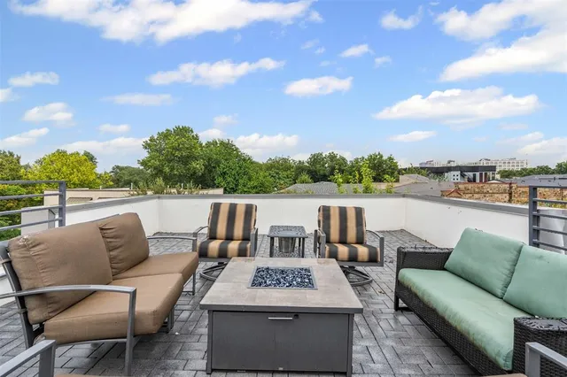 a roof deck with table and chairs and potted plants