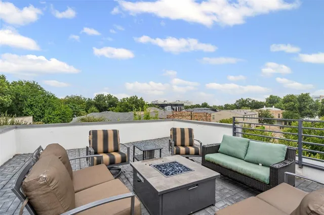a roof deck with couches and potted plants