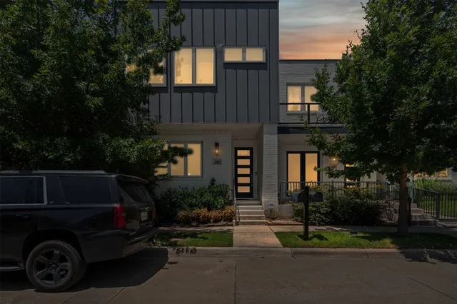 a view of a car park in front of house and trees