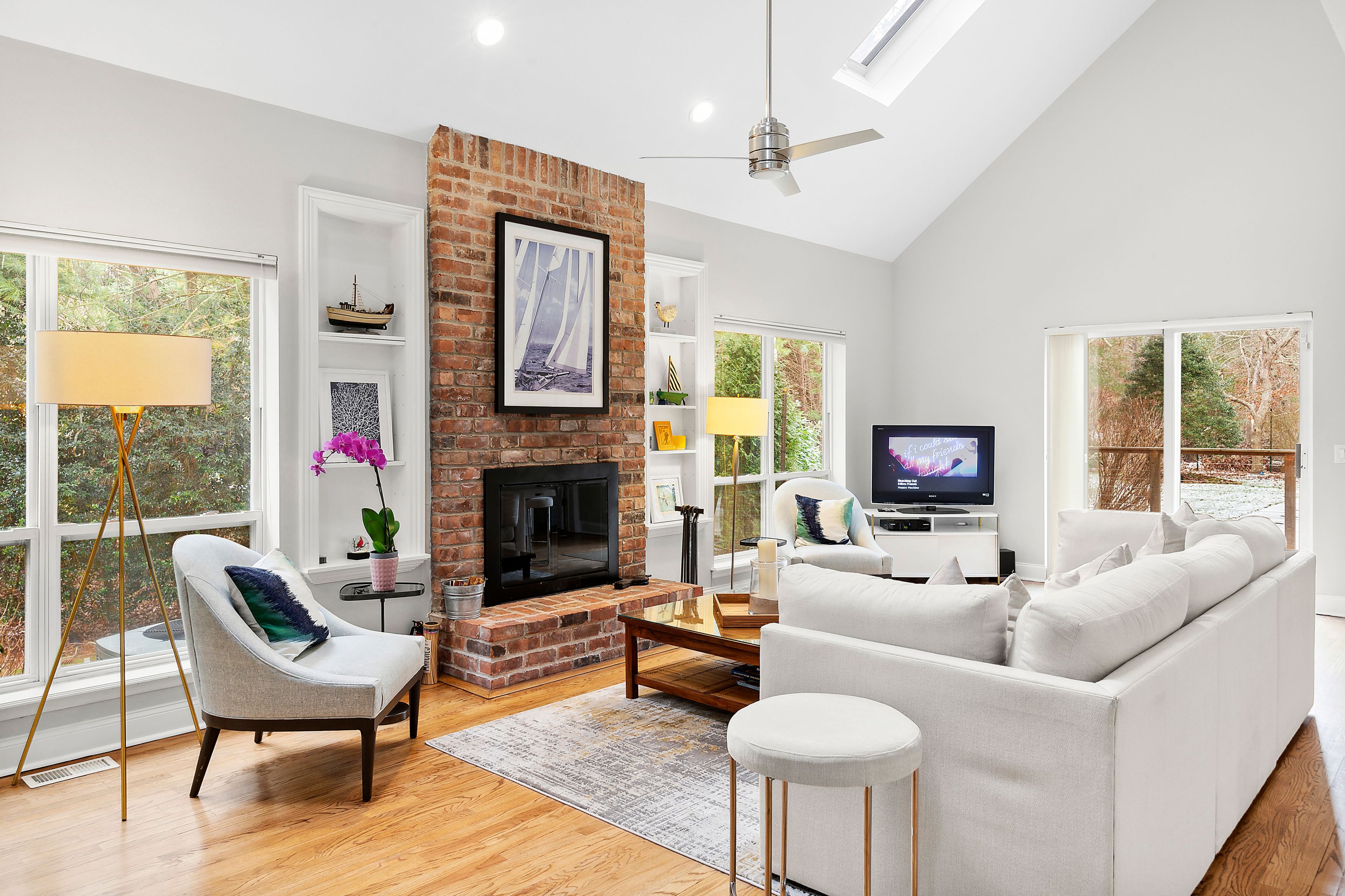 15 East East Gate Road Wainscott, NY 11975 - Photo 2 of 10 a living room with furniture a fireplace and a flat screen tv