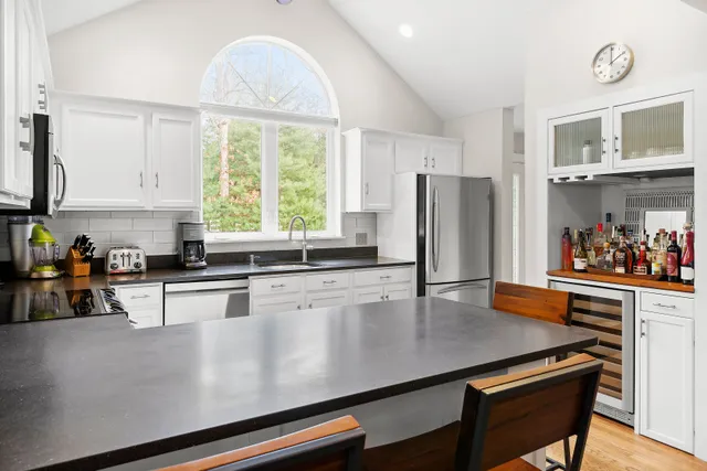 a kitchen with stainless steel appliances a table chairs and a refrigerator