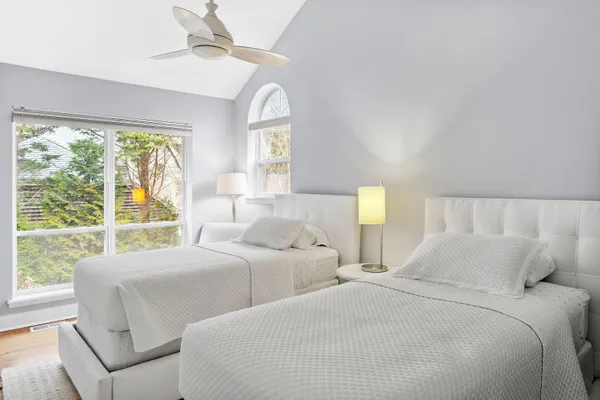 a bedroom with two beds and a large window