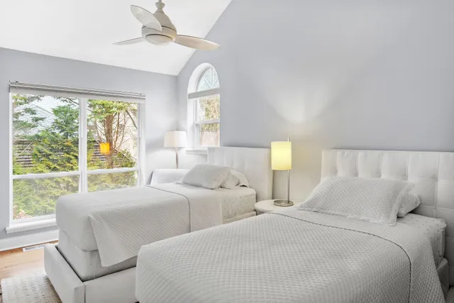 a bedroom with two beds and a large window