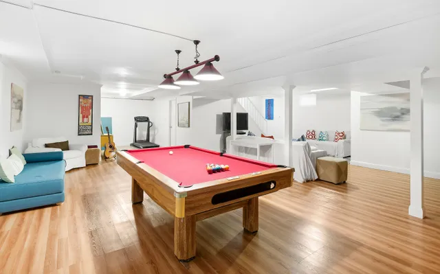 a room with pool table and wooden floor