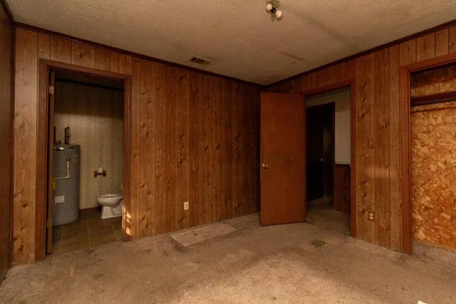 an empty room with closet and a bathroom