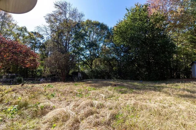 a front view of a house with a yard and trees