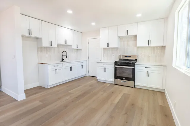 a kitchen with white cabinets and stainless steel appliances