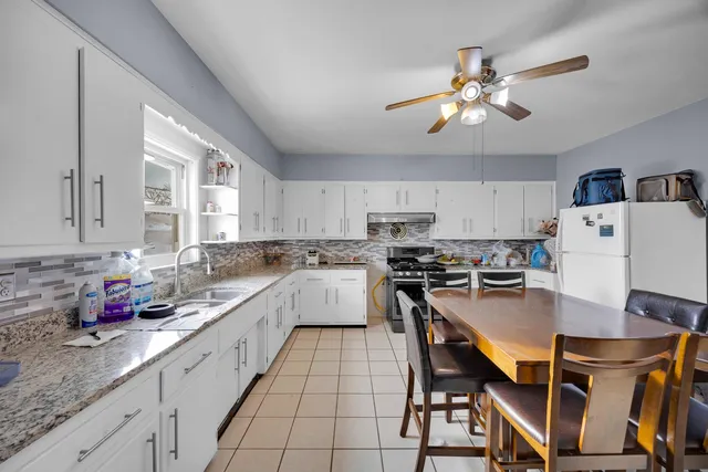 a kitchen with a dining table chairs and white cabinets